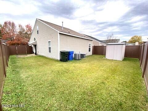 rear view of property featuring a yard and a shed