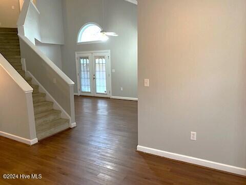 entrance foyer with french doors, dark wood-type flooring, and a high ceiling