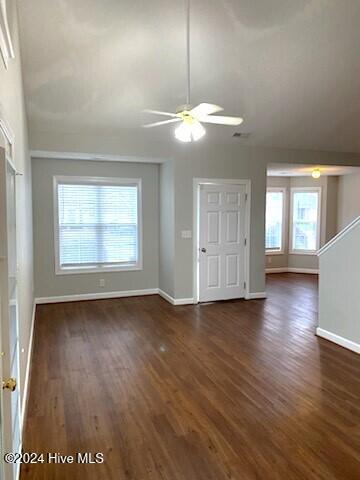 unfurnished living room with ceiling fan, dark hardwood / wood-style flooring, and a wealth of natural light