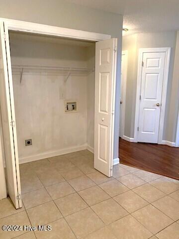 laundry room featuring hookup for an electric dryer, hookup for a washing machine, and light wood-type flooring