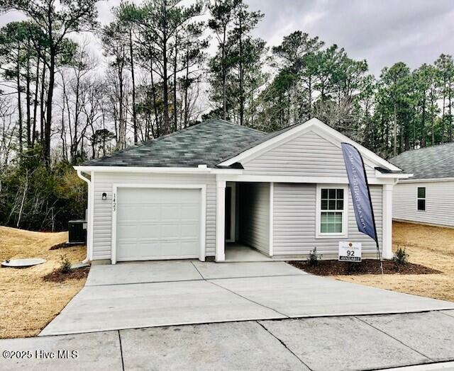 ranch-style house with a garage and central AC unit