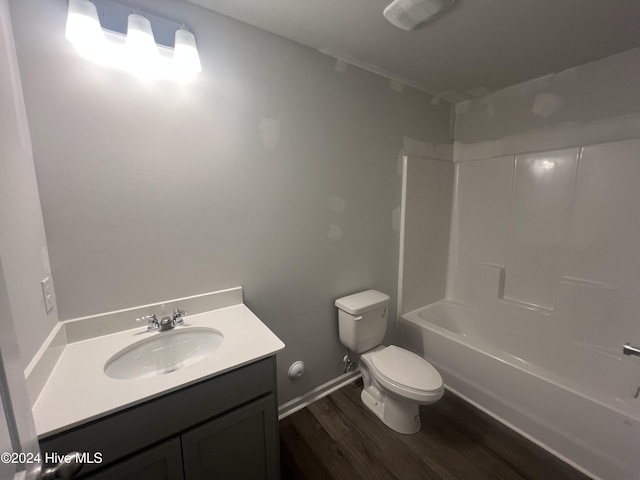 full bathroom with hardwood / wood-style flooring, tub / shower combination, toilet, and vanity