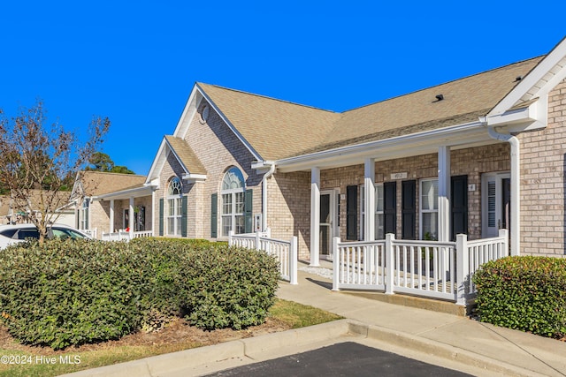 view of side of property featuring covered porch