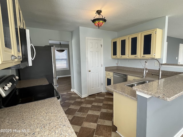 kitchen featuring appliances with stainless steel finishes, sink, a textured ceiling, and kitchen peninsula