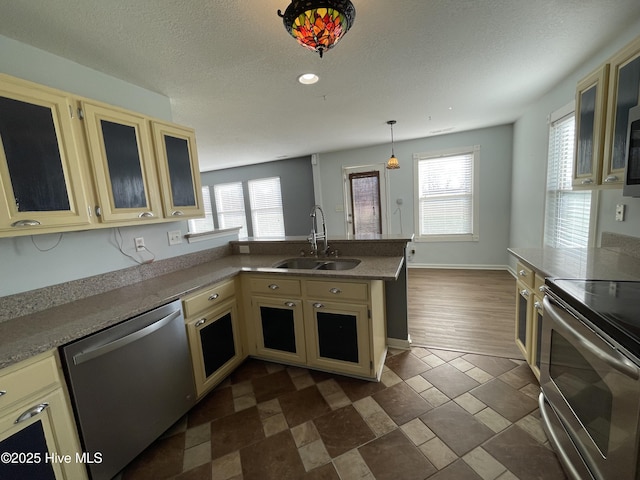 kitchen featuring stainless steel appliances, sink, a wealth of natural light, and decorative light fixtures