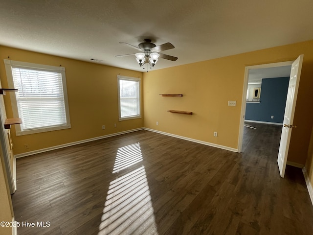 empty room featuring ceiling fan and dark wood-type flooring