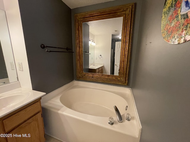 bathroom with a tub and vanity