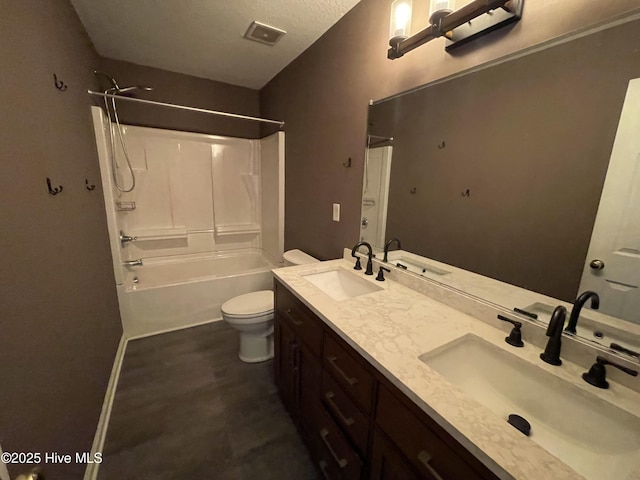 full bathroom featuring shower / bath combination, vanity, toilet, and a textured ceiling