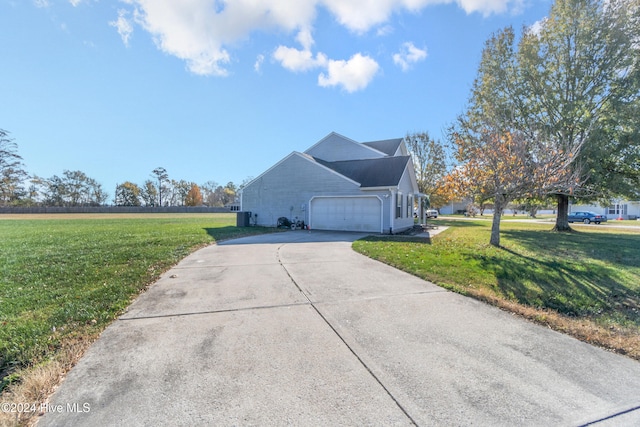 view of side of home featuring central AC, a garage, and a lawn