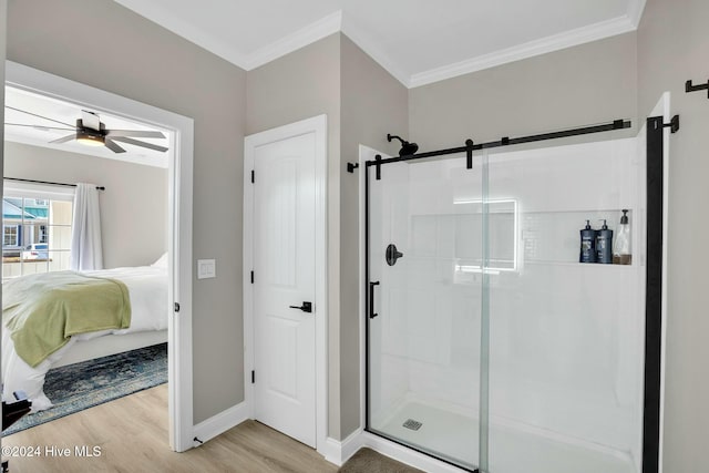 bathroom featuring ceiling fan, ornamental molding, an enclosed shower, and hardwood / wood-style flooring