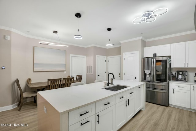 kitchen featuring stainless steel fridge with ice dispenser, decorative light fixtures, white cabinetry, and sink