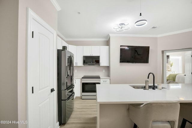 kitchen featuring a kitchen bar, stainless steel appliances, crown molding, sink, and white cabinets