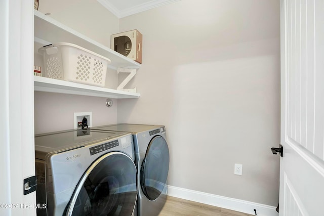 clothes washing area featuring separate washer and dryer, crown molding, and light hardwood / wood-style flooring