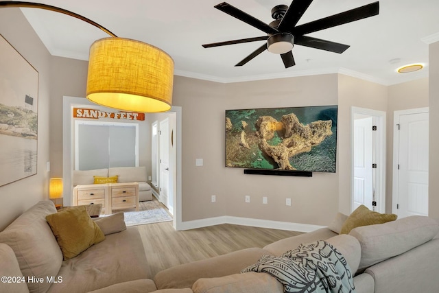 living room featuring crown molding, light hardwood / wood-style flooring, and ceiling fan