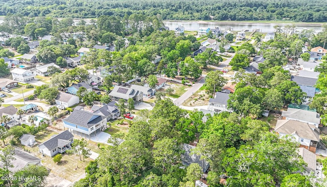 117 NW 17th St, Oak Island, NC 28465 - aerial view of property and surrounding area featuring nearby suburban area, a large body of water, and a heavily wooded area