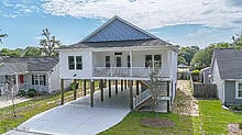 117 NW 17th St, Oak Island, NC 28465 - coastal home with a carport, covered porch, and driveway