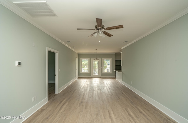 117 NW 17th St, Oak Island, NC 28465 - spare room featuring crown molding, baseboards, a ceiling fan, light wood-style floors, and a chandelier
