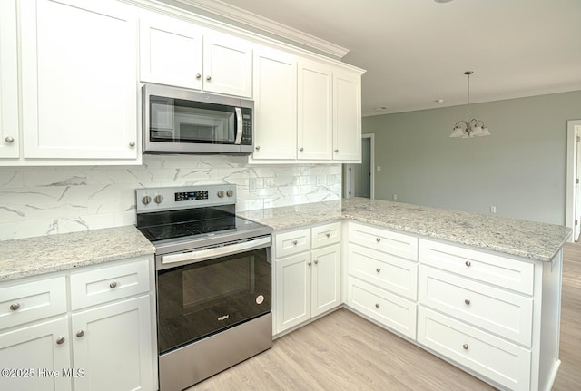 117 NW 17th St, Oak Island, NC 28465 - kitchen featuring appliances with stainless steel finishes, a peninsula, a chandelier, light wood-style floors, and white cabinets