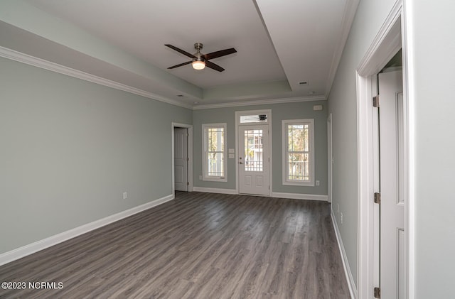 spare room with dark hardwood / wood-style floors, ceiling fan, crown molding, and a tray ceiling