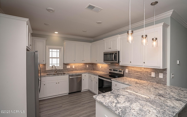 kitchen with pendant lighting, white cabinets, sink, kitchen peninsula, and stainless steel appliances