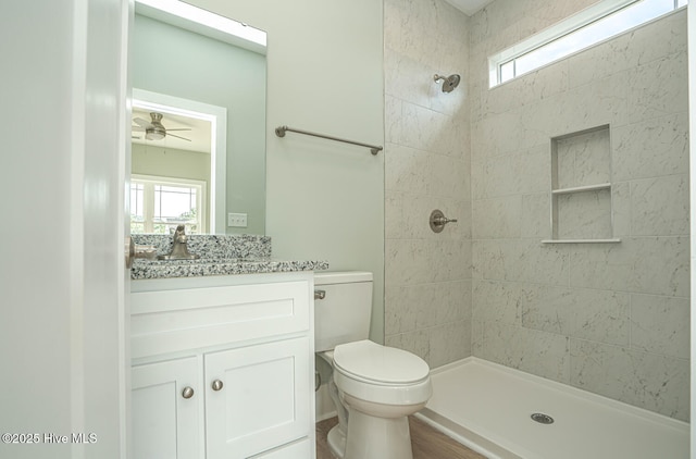 117 NW 17th St, Oak Island, NC 28465 - bathroom featuring tiled shower, vanity, toilet, and healthy amount of natural light