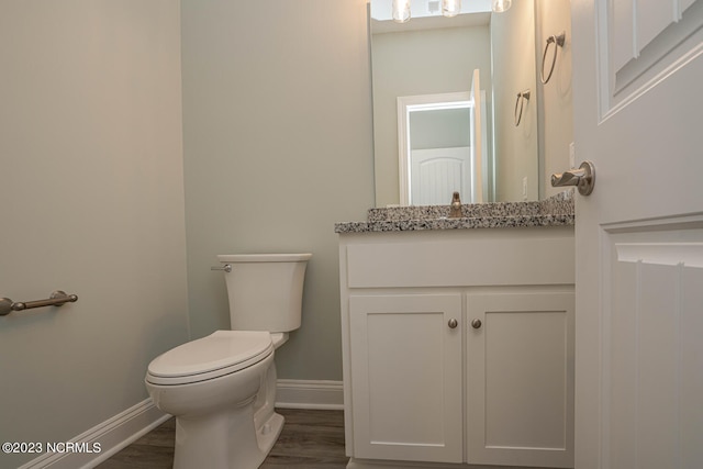 bathroom featuring vanity, wood-type flooring, and toilet