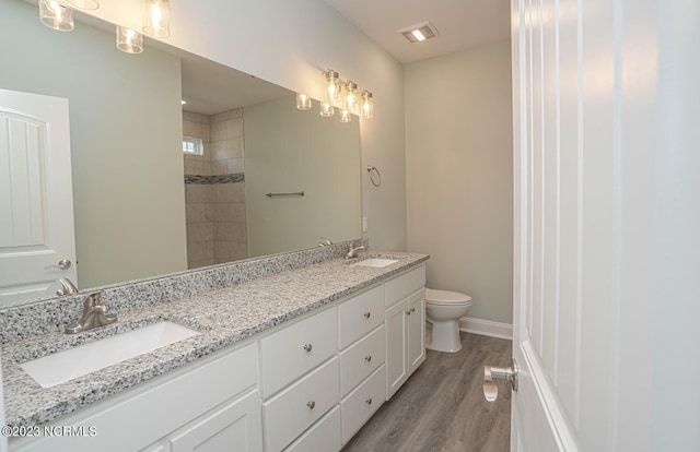 bathroom with toilet, vanity, and hardwood / wood-style flooring