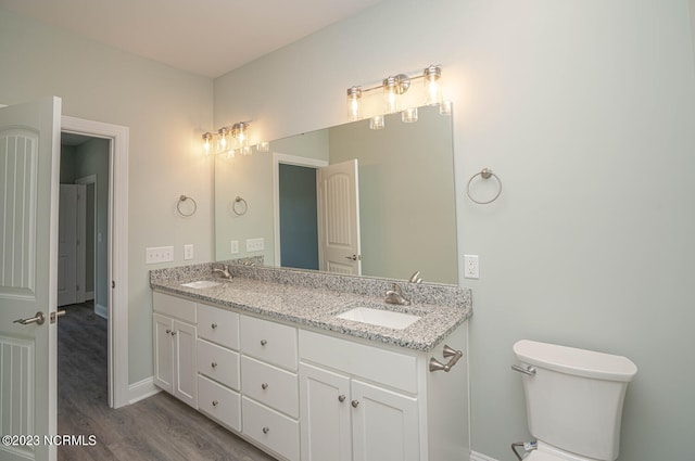 bathroom featuring toilet, vanity, and hardwood / wood-style flooring