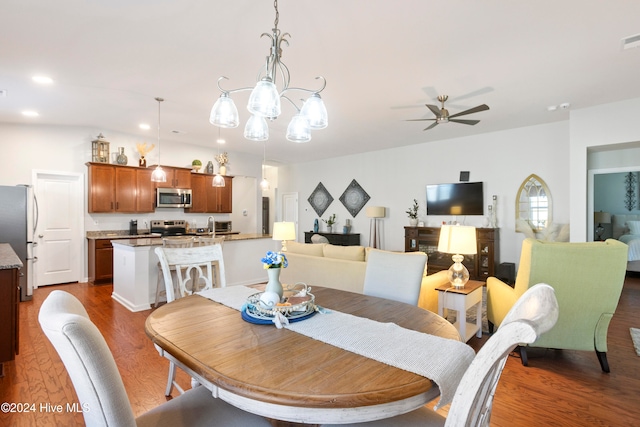 dining room featuring sink, ceiling fan with notable chandelier, and dark hardwood / wood-style floors