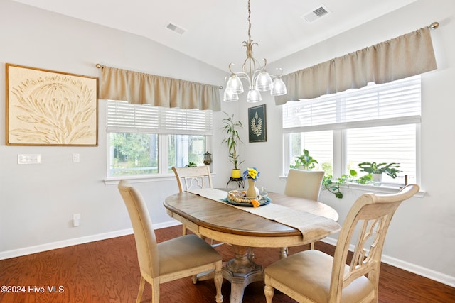 dining room with dark wood-type flooring, vaulted ceiling, and an inviting chandelier