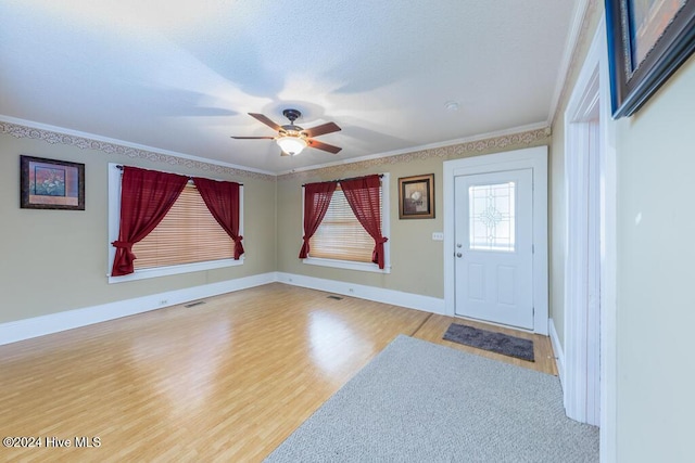 entryway featuring hardwood / wood-style flooring, ceiling fan, and ornamental molding