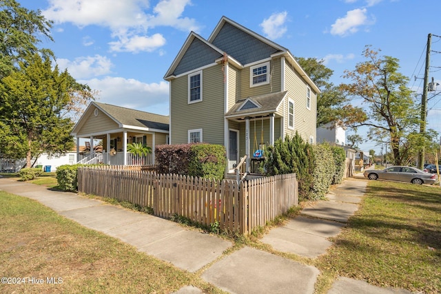 view of front of home featuring covered porch and a front lawn