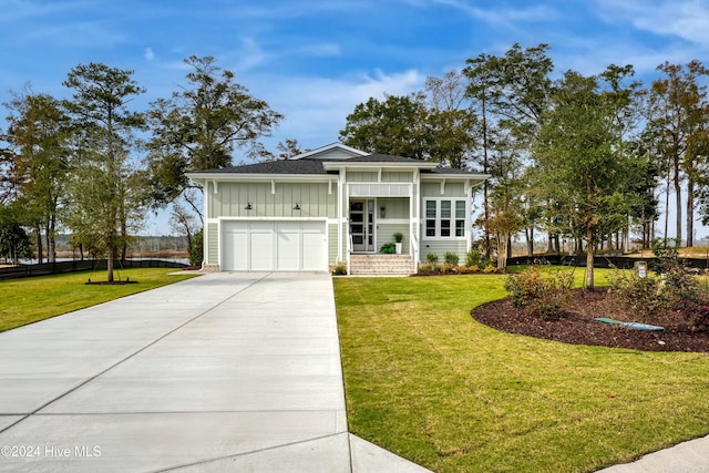 view of front of property with covered porch, a garage, and a front lawn