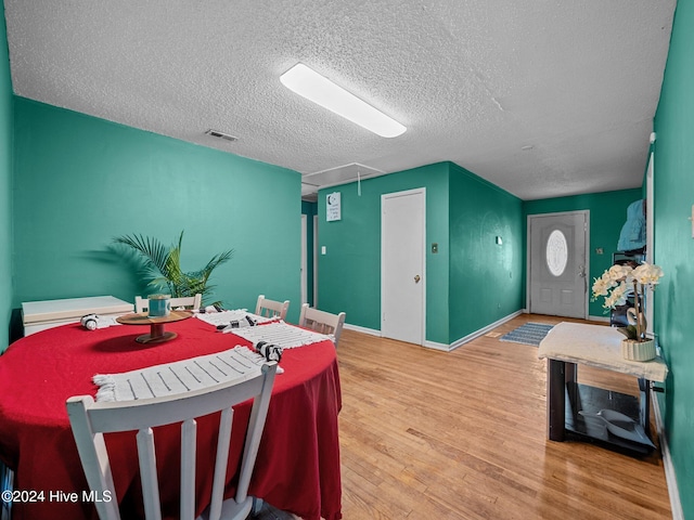 dining area with a textured ceiling and hardwood / wood-style flooring