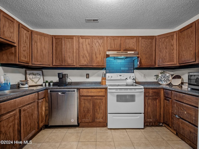 kitchen featuring light tile patterned floors, a textured ceiling, and stainless steel appliances