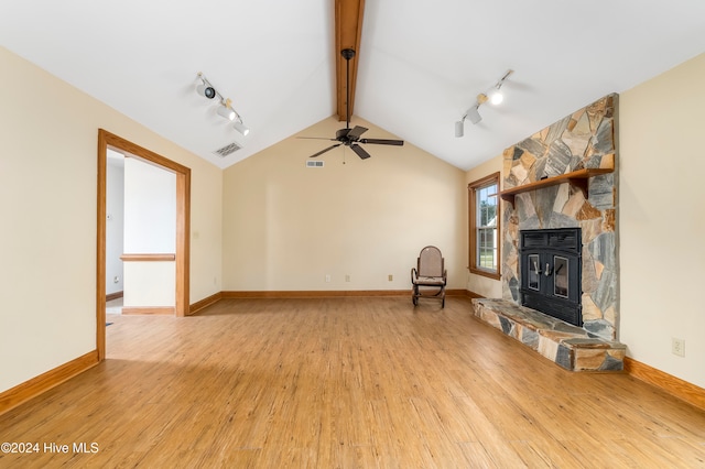 unfurnished living room featuring lofted ceiling with beams, rail lighting, light hardwood / wood-style floors, and ceiling fan