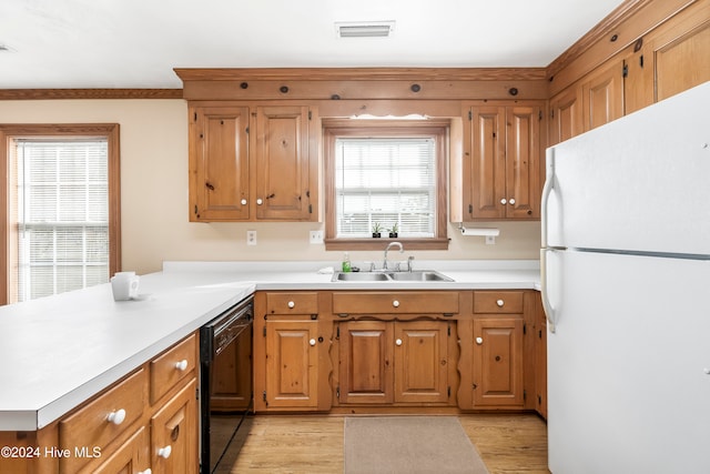 kitchen featuring dishwasher, white refrigerator, sink, and a wealth of natural light