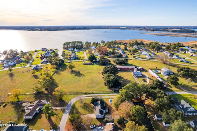 aerial view at dusk featuring a water view