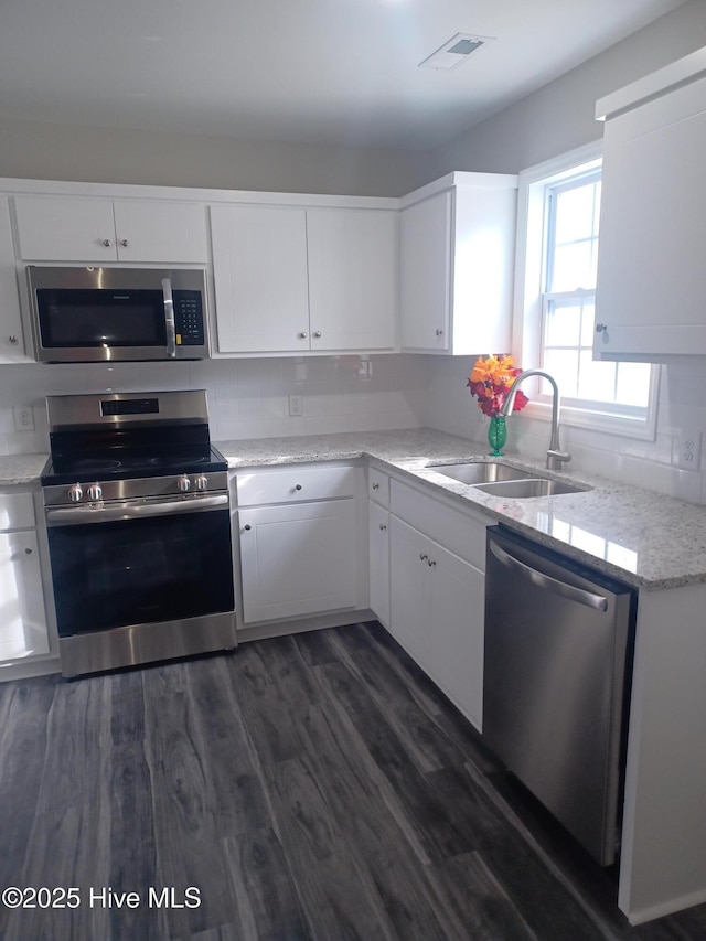 kitchen featuring dark hardwood / wood-style flooring, sink, white cabinets, and appliances with stainless steel finishes