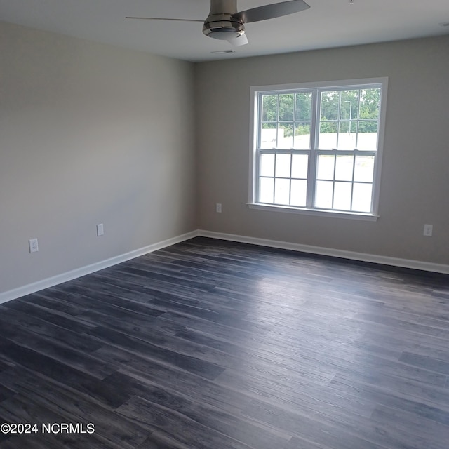 empty room with ceiling fan and dark wood-type flooring