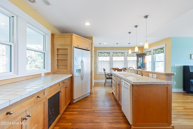 kitchen featuring tile countertops, white appliances, and a wealth of natural light