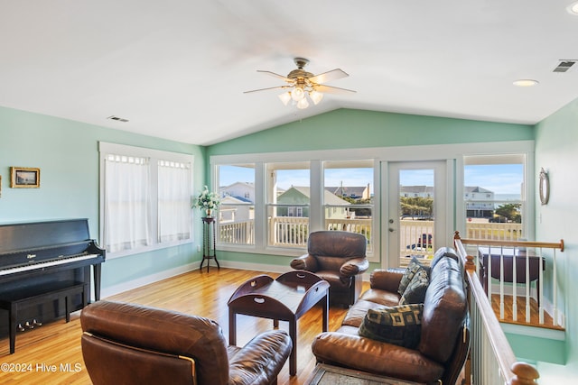 living room with ceiling fan, light hardwood / wood-style flooring, and vaulted ceiling