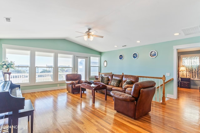 living room with ceiling fan, light wood-type flooring, and lofted ceiling