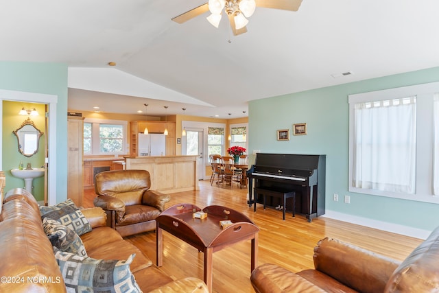 living room featuring ceiling fan, sink, light hardwood / wood-style floors, and lofted ceiling