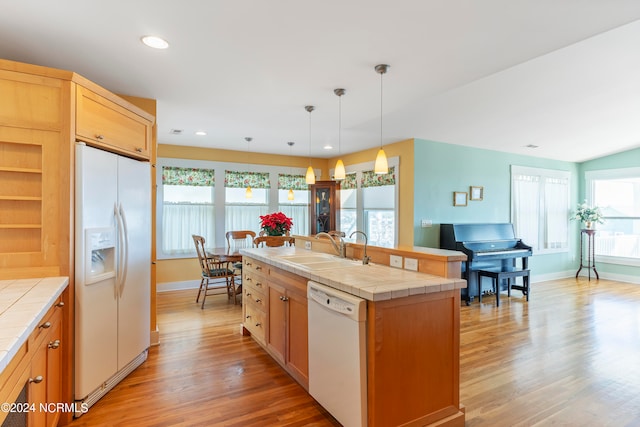 kitchen with tile counters, a healthy amount of sunlight, and white appliances