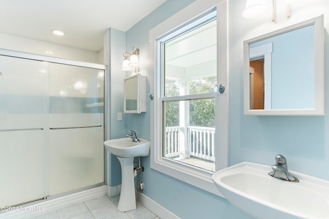 bathroom with tile patterned flooring, a shower with shower door, and sink