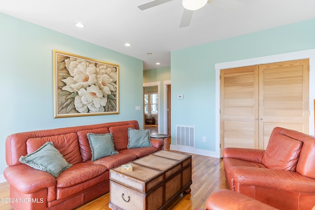 living room featuring ceiling fan and light hardwood / wood-style floors