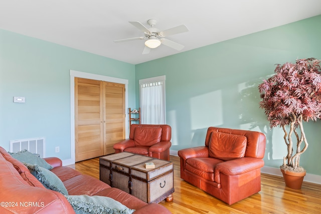 living room featuring light wood-type flooring and ceiling fan