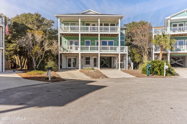 exterior space with french doors, a balcony, and a carport