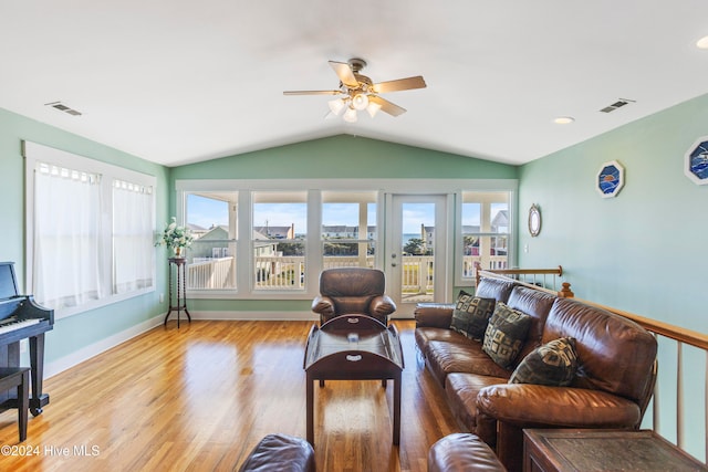 living room with ceiling fan, light hardwood / wood-style floors, and vaulted ceiling